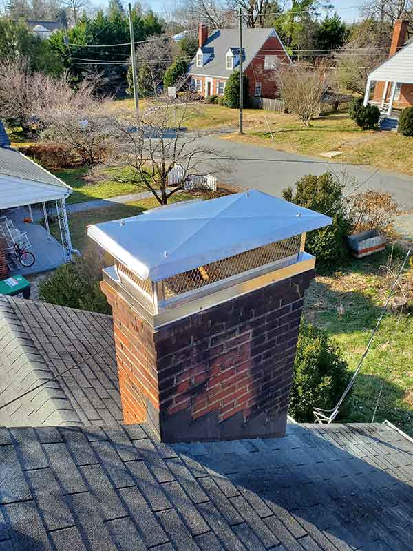 Stainless Steel Custom Chimney Cap with home and bicycle in the background