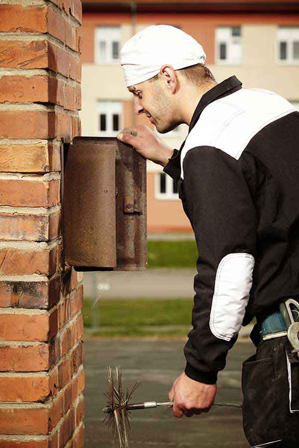 The Chimney Guys VA -original photo sweeping and inspection Tech Visual Inspection holding sweep brush