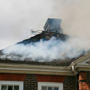 roof on fire surrounded by dark smoke