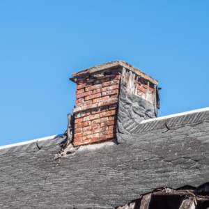 a masonry chimney with discoloration, missing mortar, and broken bricks