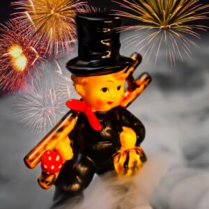 a chimney sweep ceramic figure with smoke and fireworks in the background