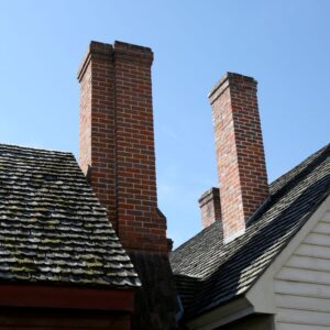 two brick chimneys coming out of two neighboring houses