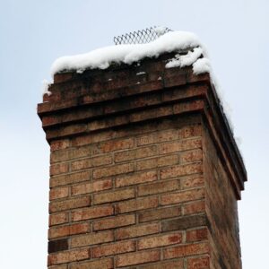 a large brick chimney with snow on the top