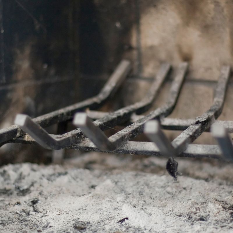 stock photo of fireplace grate a fireplace grate in a firebox with ash underneath it